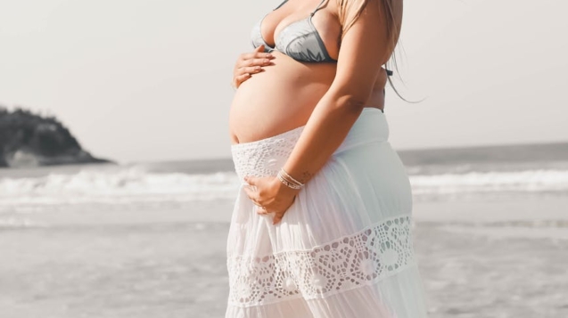 woman in white and pink floral dress standing on beach